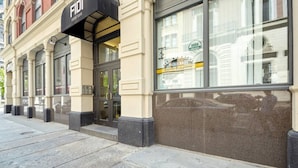 A building facade with a black awning labeled "FIDI" and a sign for "Pierce Bros Coffee Roasters" indicating a coffee shop inside. - Boston Financial District 1BR | Walk to anything! (Boston)