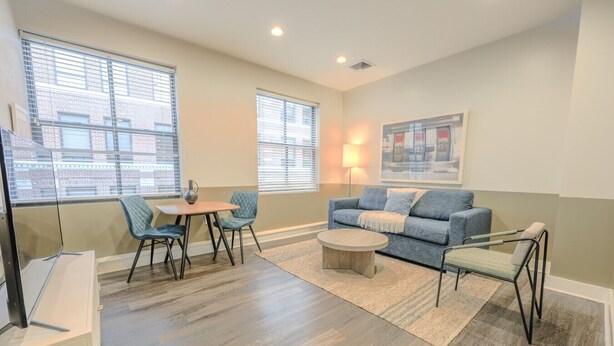 A living room with a sofa, two chairs, a coffee table, and a TV. - Boston Financial District 1BR | Walk to anything! (Boston)