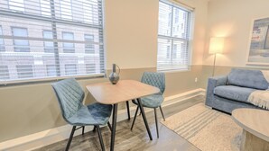 A modern living room with a dining table, two chairs, a sofa, and a lamp. - Boston Financial District 1BR | Walk to anything! (Boston)