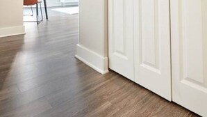 A hallway with a wooden floor leading to a white door. - Milk153-6G-1/1 · Bright FIDI 1br | Centrally Located (Boston)