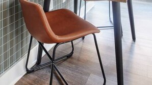 A modern dining area with a wooden table and a single brown leather chair. - Milk153-6G-1/1 · Bright FIDI 1br | Centrally Located (Boston)