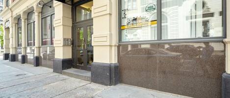A building with a black awning labeled 'FIDI' and a sign for 'Pierce Bros Coffee Roasters' with USDA organic certification.
