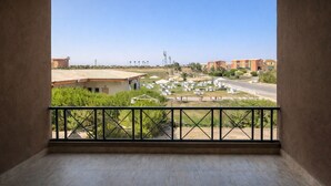 Un balcón con vista a una zona residencial, con casas y una calle.