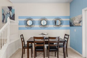 Ein Essbereich mit weißer Reling, blauer Wand und drei an der Wand befestigten Spiegeln.