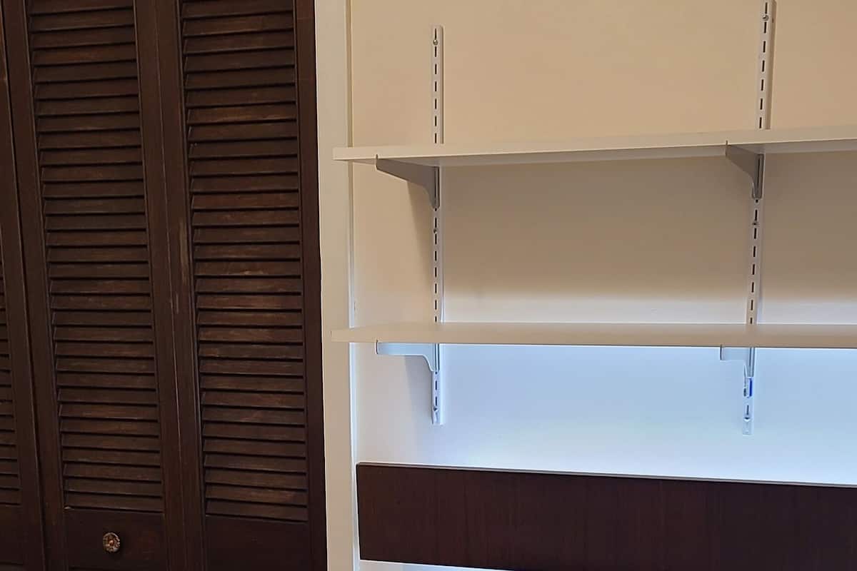 Une pièce comprenant un bureau, une chaise, une poubelle et une armoire.