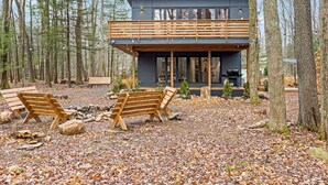 A modern cabin with a balcony, surrounded by a forest. - Superb 6-bedroom house with HVAC in charming Pocono Pines (Pocono Pines)