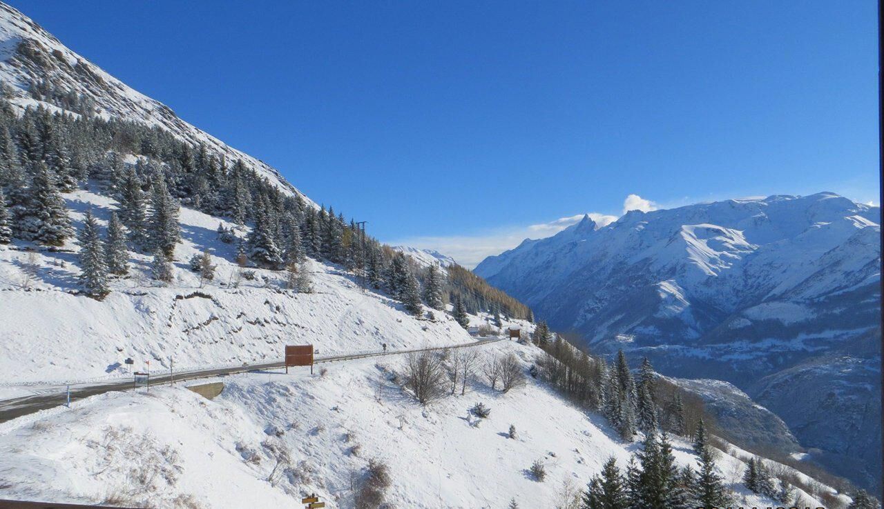 A snow-covered mountain road with a clear blue sky.
