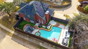 Propiedad residencial con piscina, patio y paneles solares en el techo.