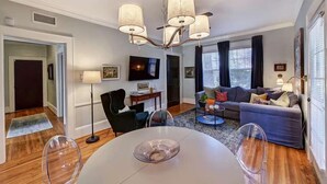 Una sala de estar moderna con una mesa de comedor, sofá y televisor.