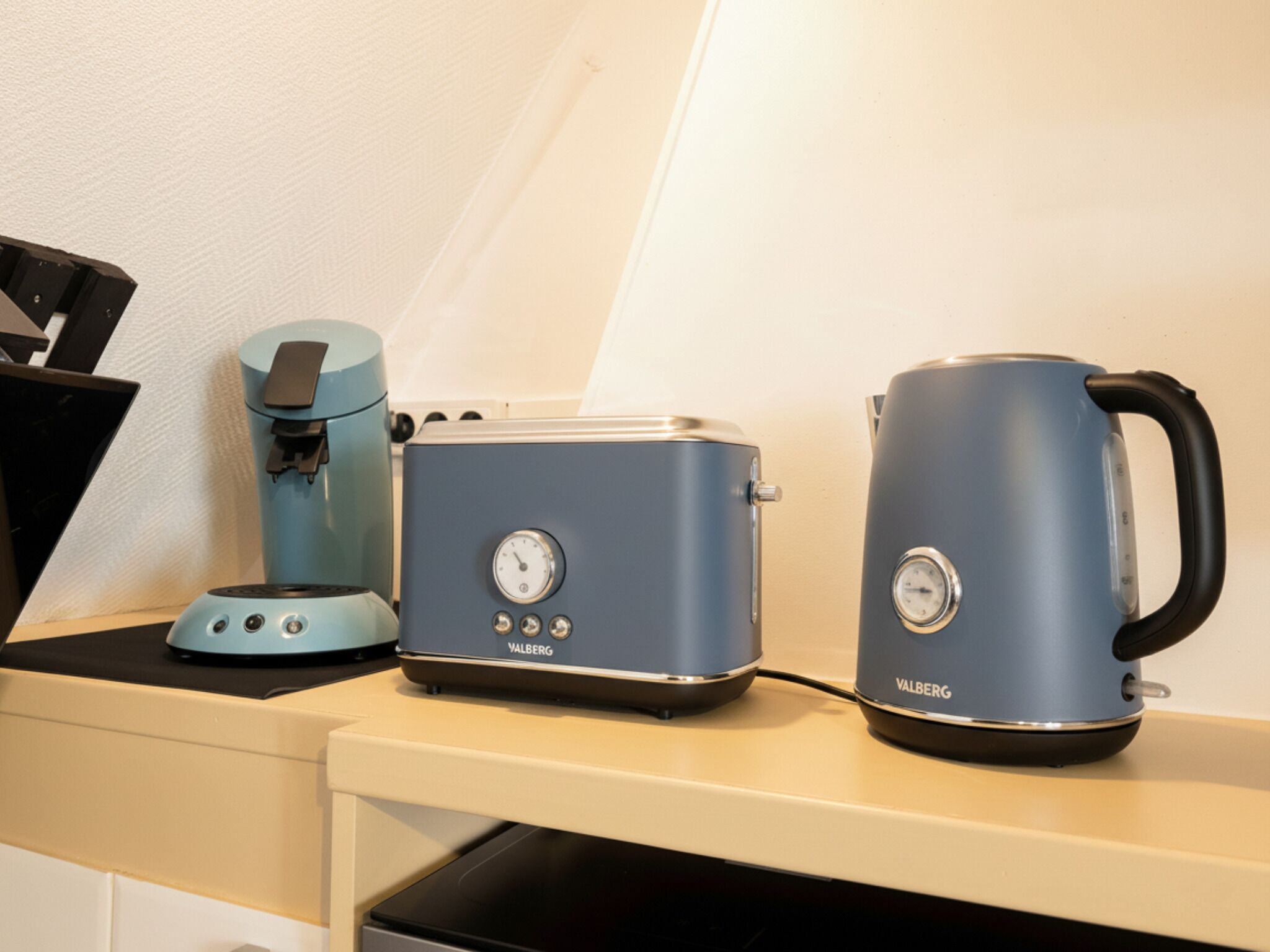 En köksbänk med en kaffebryggare, en brödrost och en vattenkokare.