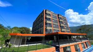 A multi-story building with a modern design, featuring balconies and a flat roof.