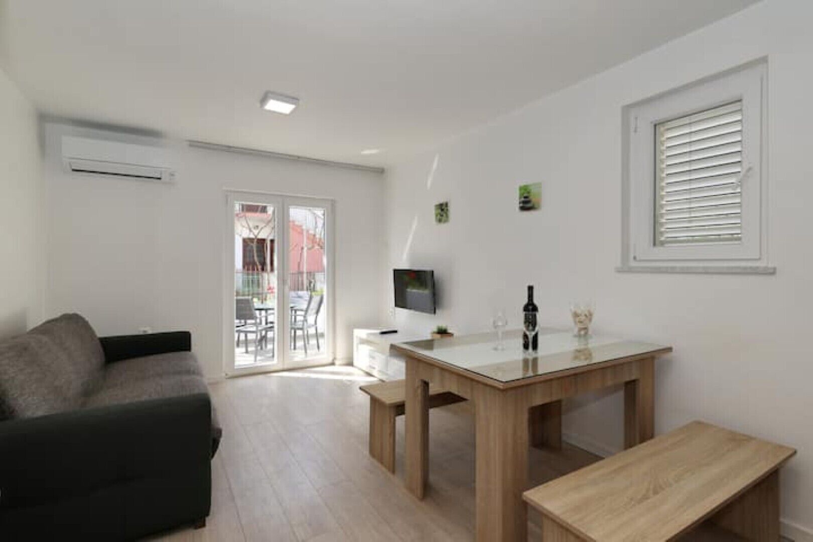 Een moderne woonkamer met een bank, een eettafel en een televisie.