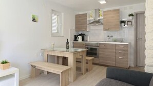 Eine kleine Küche mit Holzausstattung, einem eingebauten Ofen und einem Essbereich mit einer Bank.