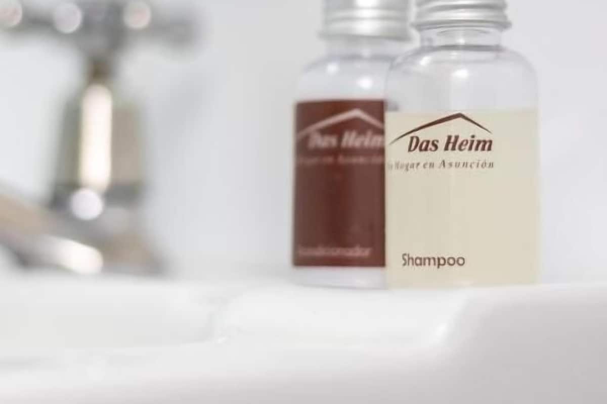 Two bottles of Das Heim shampoo in a bathroom.