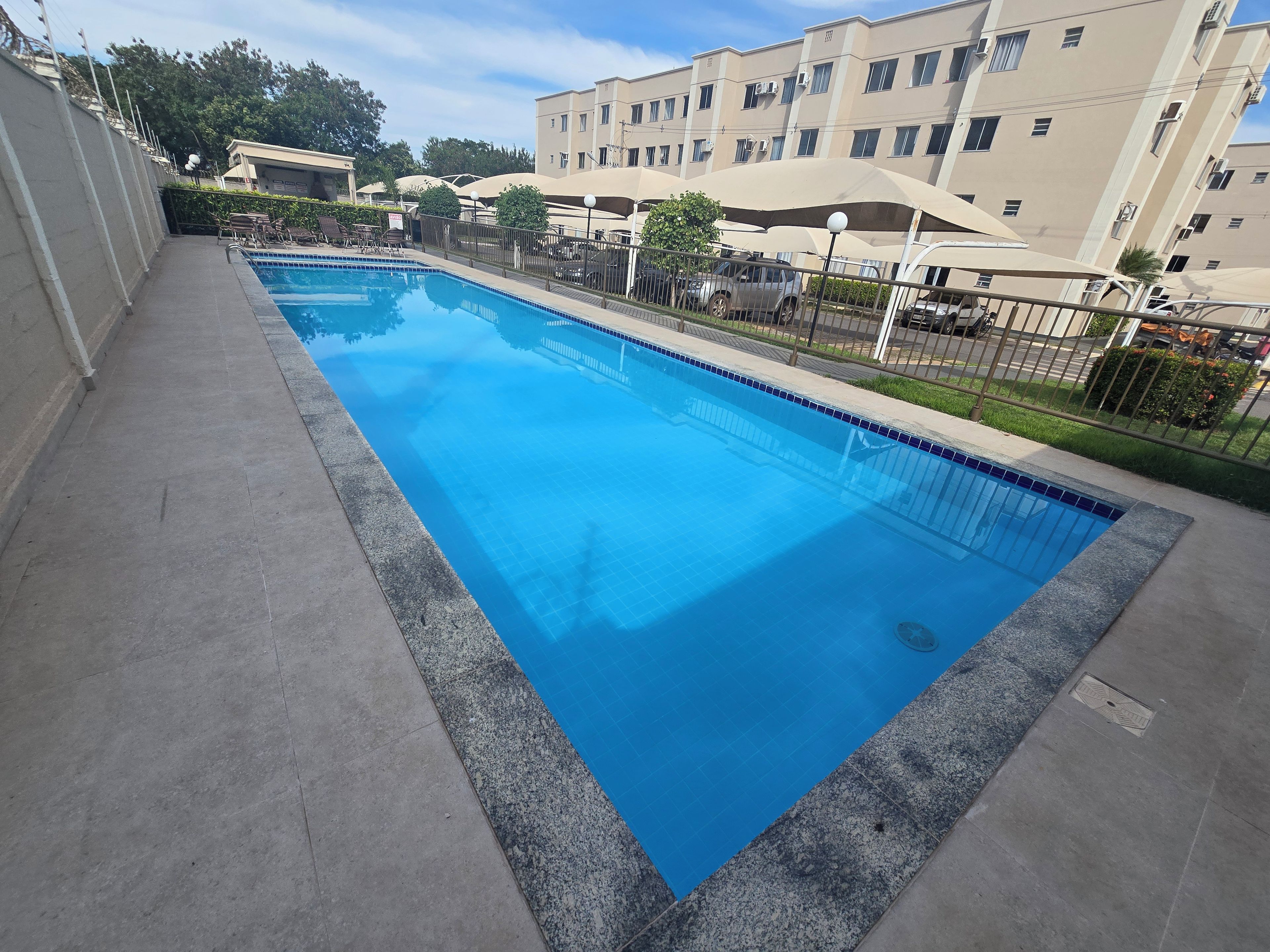 Ein rechteckiger Pool mit einer gefliesten Kante, umgeben von einer Betonplattform.