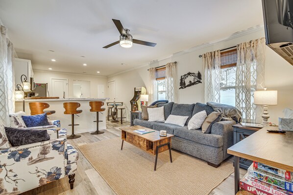 A living room with a sofa, coffee table, and a TV stand.
