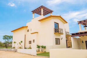 A two-story house with a balcony, a pergola, and a small garden. - Spacious 4-bedroom villa in fantastic Cabo San Lucas with AC (Cabo San Lucas)