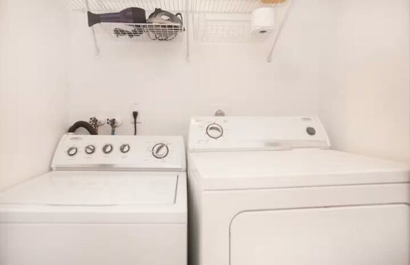 A laundry area with two white washing machines and a drying rack with a towel and a hairdryer. - Collins 2 Bedroom with Free Parking by Deco 305 (Miami Beach)