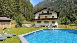 Un edificio de dos pisos con una piscina delantera.