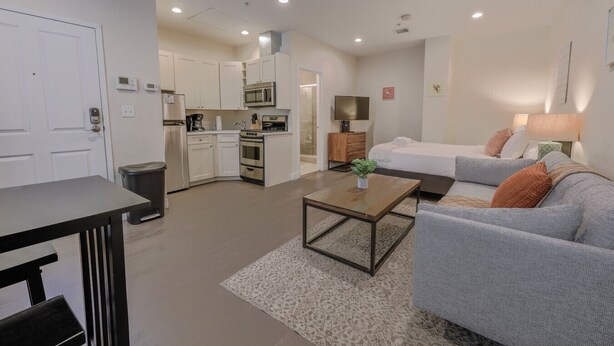 A modern apartment with a kitchen, a living area with a sofa and coffee table, and a bedroom with a bed and nightstand. - Simple Studio -Walk to MGH, Beacon Hill, North End (Boston)