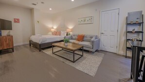 A modern living room with a sofa, a bed, a coffee table, and a TV. - Simple Studio -Walk to MGH, Beacon Hill, North End (Boston)
