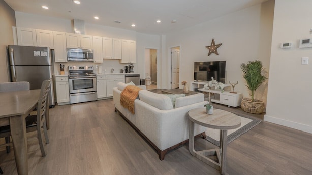 A modern kitchen with white cabinets, stainless steel appliances, and a central island. - Prime Location | Beacon Hill & Financial District (Boston)