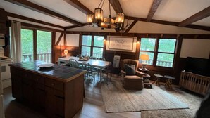 A spacious kitchen with a large island, wooden beams, and a view of the outdoors. - Chalet on the Lake, Fireplace, Washer/Dryer, Snowmobile, ATV, Sleeps 8 (Woodruff)