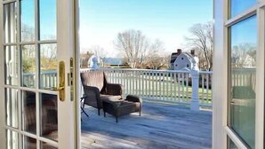Um terraço com uma cadeira e uma cerca branca.
