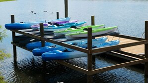 Un muelle de madera con varias kayaks y canoas.