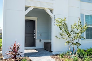 A modern building with a black door, a small porch, and a number '16161' on the wall. - Magical 5Bd Themed w/ Waterpark Near Disney 16161 (Clermont)