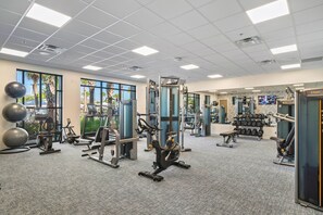 A gym with various exercise equipment, large windows, and a ceiling with fluorescent lights. - Magical 5Bd Themed w/ Waterpark Near Disney 16161 (Clermont)