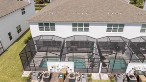 Un immeuble résidentiel doté d’un grand patio clos, de climatiseurs extérieurs et d’une piscine.