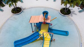 Une aire de jeux avec des toboggans et une structure d’escalade.