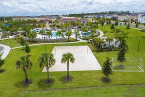 A resort with a pool area, palm trees, and a sports field. - Stunning 4Bd w Pool Gameroom Solara Resort 9008 (Kissimmee)