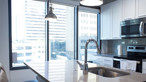 Una cocina moderna con un ventanal grande, electrodomésticos de acero inoxidable y un diseño minimalista.