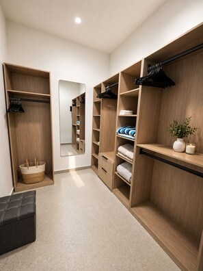 A walk-in closet with wooden shelving, a mirror, and a bench. - Luxury 6BR Villa Near Eagle Beach with Pool, Volleyball & Putting Green (Oranjestad)