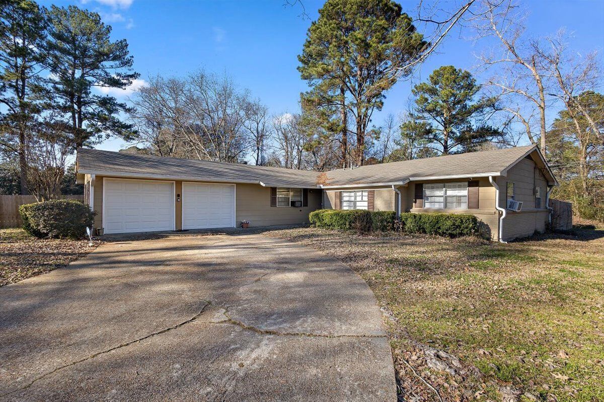 A two-story house with a garage, a driveway, and a lawn.