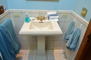 Een douche, handdoeken, zeep, toiletpapier