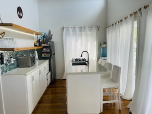 A compact kitchen with a dining area, featuring a microwave, toaster, and a sink. - Place to stay in Utila ,fully furnished house ready for you. (Utila)