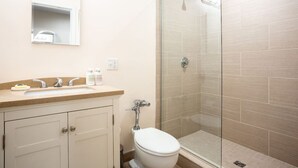 A bathroom with a toilet, sink, and glass shower enclosure. - Center of Boston Studio Pet Friendly | Laundry (Boston)