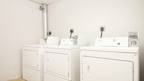 A laundry room with two white Whirlpool washers and dryers, a metal pipe on the wall, and a power outlet. - Downtown Luxury 1BR | Pets Welcome | W/D in Bldg (Boston)