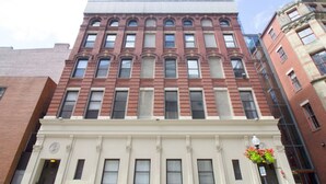 A multi-story building with a classic architectural style, featuring a prominent entrance with a white facade and decorative elements. - Downtown Luxury 1BR | Pets Welcome | W/D in Bldg (Boston)