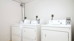 A laundry room with two white Whirlpool washers and dryers, a metal vent, and a power outlet. - Studio walking distance to MGH and Tufts Medical (Boston)