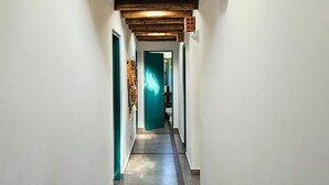 A narrow hallway with white walls, a wooden ceiling, and a green door at the end. - w*| Spacious 4BR Country House with Pool in Mala (Asia)