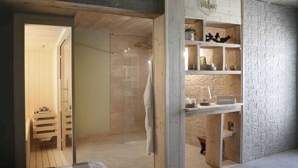 A room with a wooden floor, a glass shower enclosure, and a white brick wall. - Villa ULIKA with private pool and sauna (Malinska)
