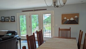 Un comedor con mesa y sillas de madera, un sofá y un cuadro en la pared.