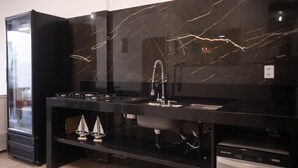 A kitchen with a black marble countertop, stainless steel appliances, and a built-in dishwasher. - @durhambeachhouse your vacation home in Porto Seguro. Comfort and privacy. (Porto Seguro)