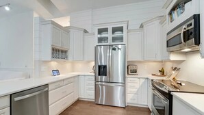 A modern kitchen with white cabinetry, stainless steel appliances, and a built-in oven. - The Gardens Estate - Luxury Resort Retreat Near PGA Golf, Beaches, & Jupiter (West Palm Beach)