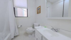 A bathroom with a toilet, sink, and shower.