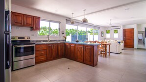 Uma cozinha moderna com armários de madeira, eletrodomésticos de aço inoxidável e uma ilha grande.